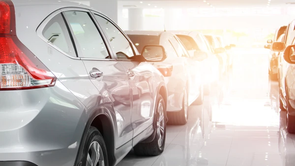 Showroom automobile intérieur avec véhicules neufs exposés sur sol brillant