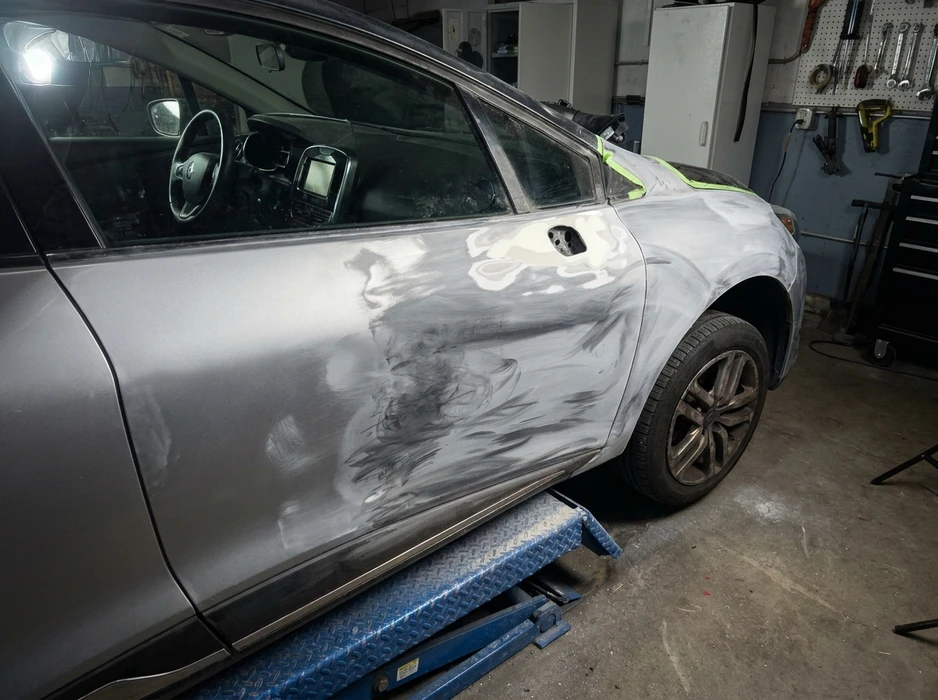 Carrosserie SUV gris en atelier de réparation, posée sur rampe d'élévateur