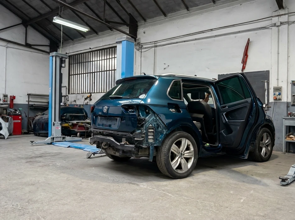 Atelier de carrosserie industriel, VW Tiguan bleu pétrole en cours de réparation collision