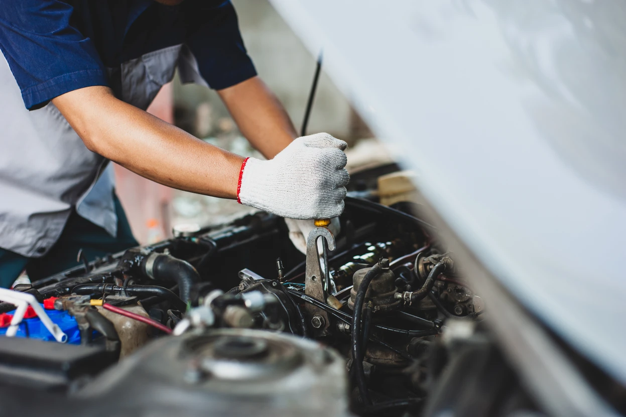 Mécanicien automobile travaillant sous le capot d'un véhicule dans un garage